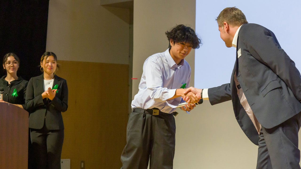NIS students walk-a-thon Cheque presentation and handshake