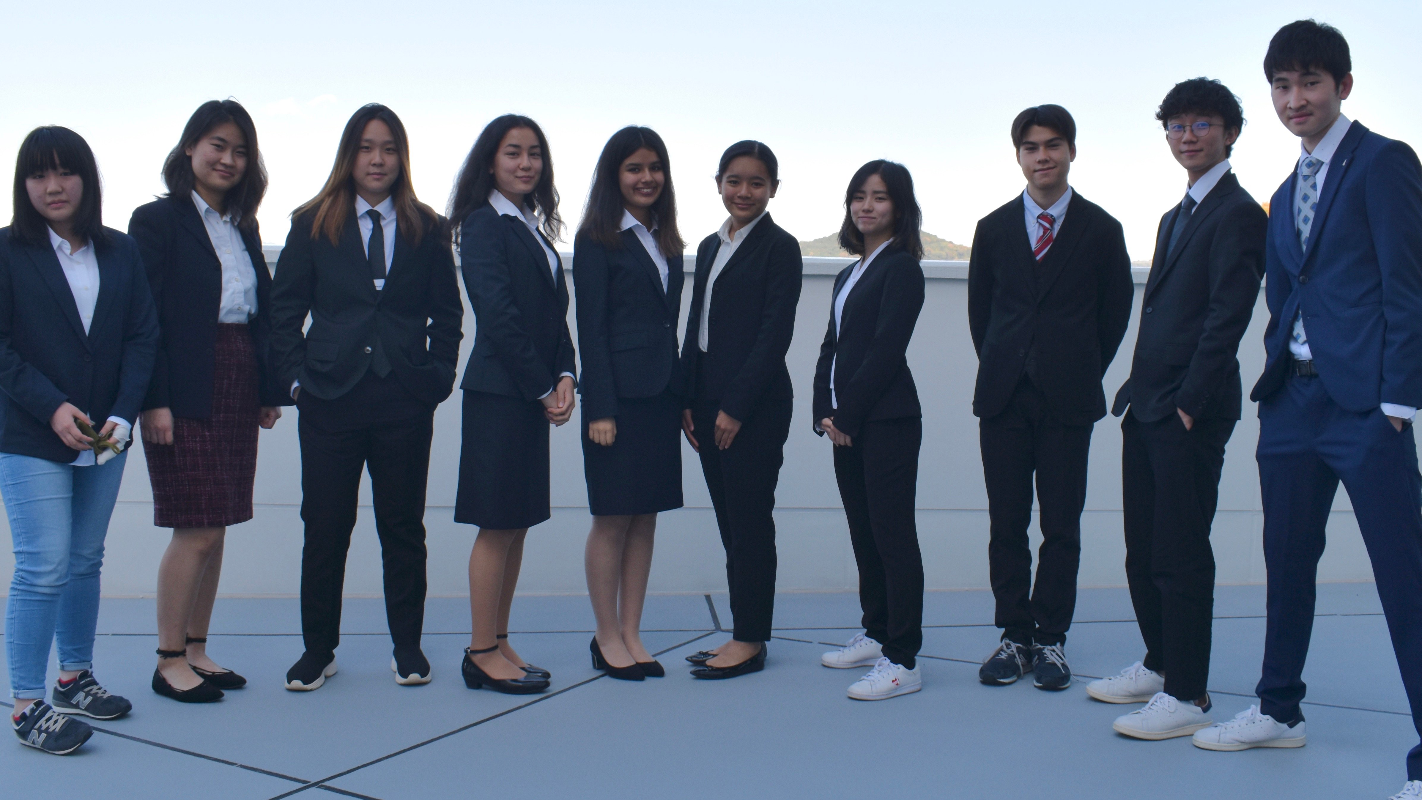 10 students standing in business attire 