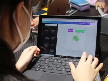 A girl edits her logo design using her computer.