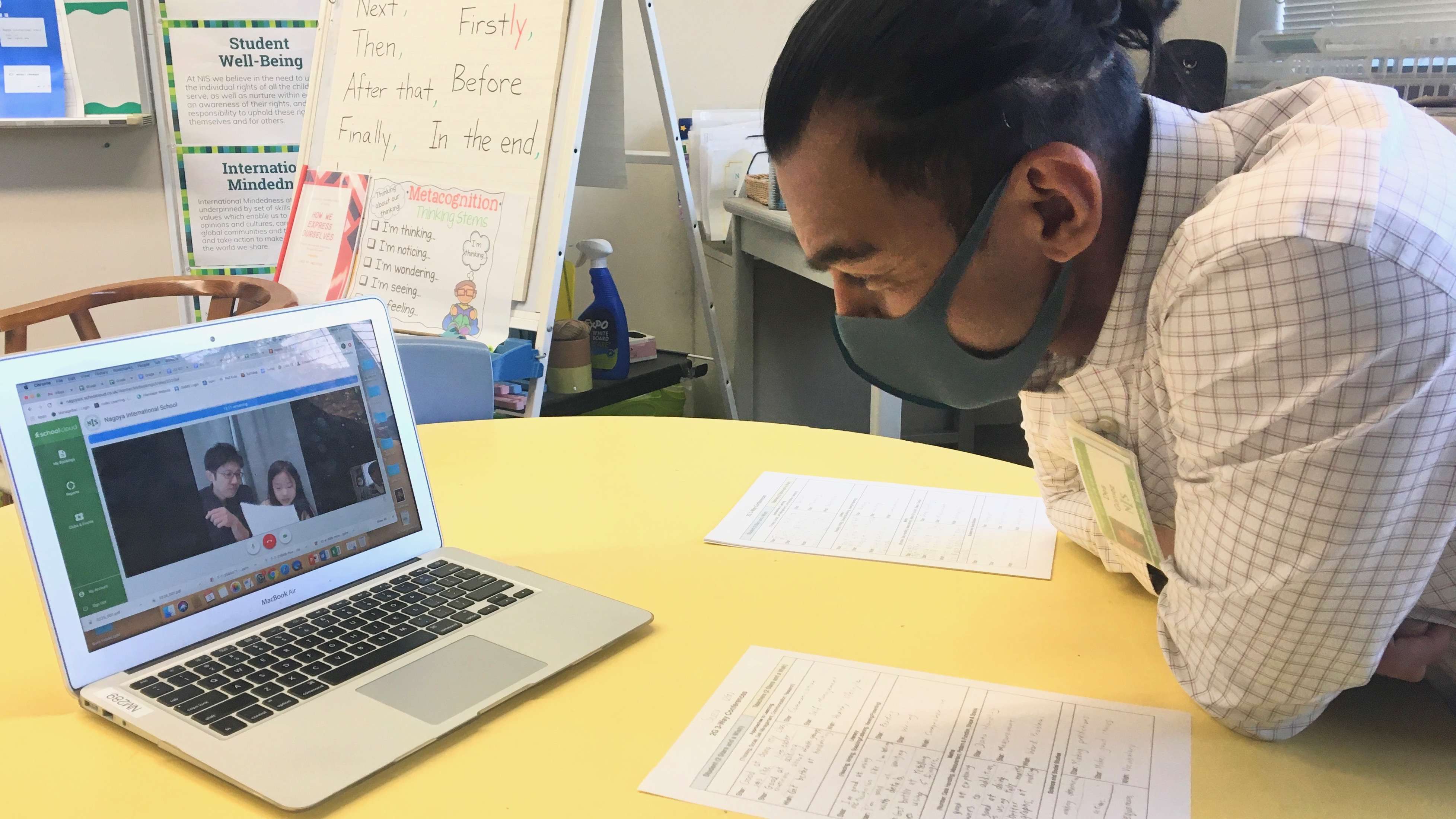 A teacher having an online conference with a student and her parent