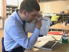 A teacher showing a student work during an online conference with a student and her parents