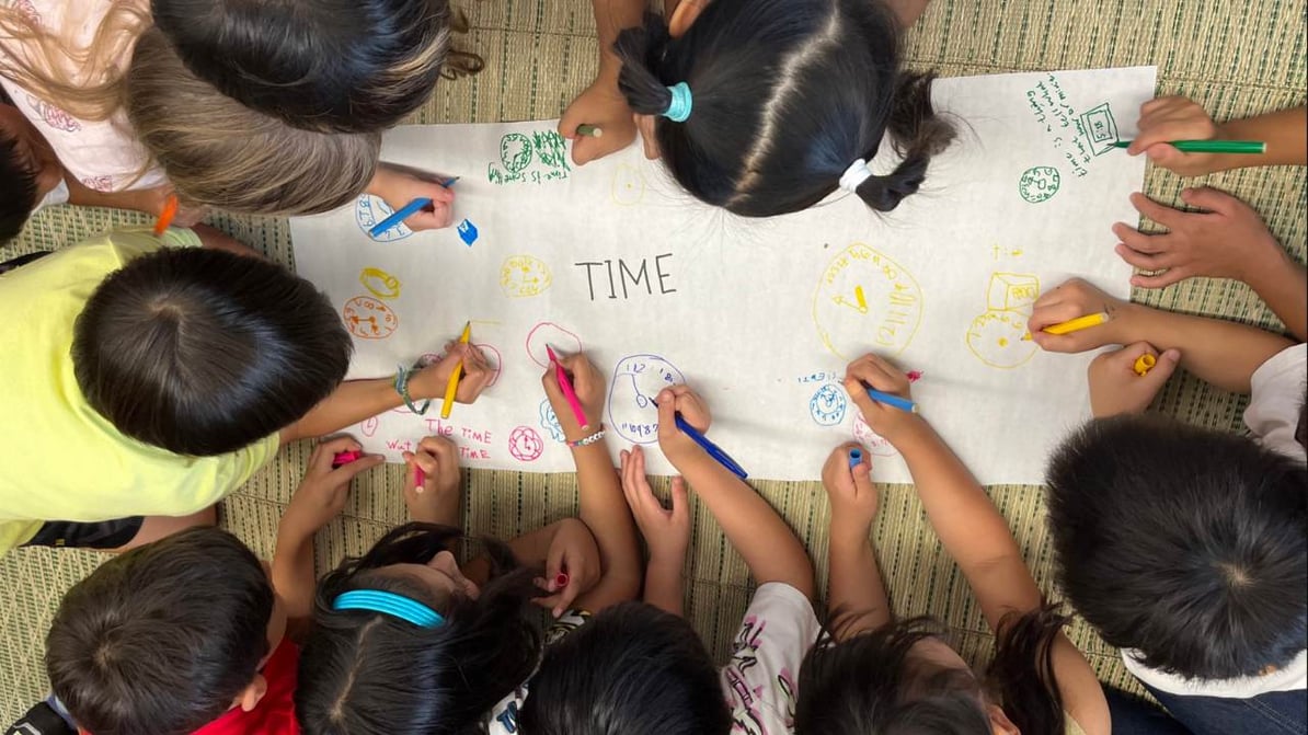 kids writing together on a poster 