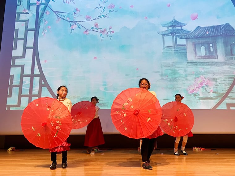 lunar new year student performance with umbrellas