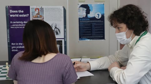 A teacher consults with a student about her idea for her Theory of Knowledge exhibit.